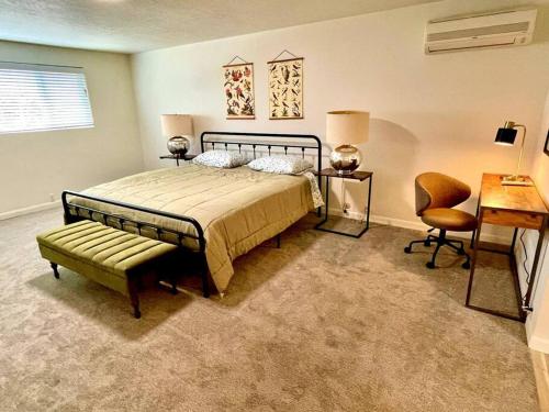 ein Schlafzimmer mit einem Bett, einem Stuhl und einem Schreibtisch in der Unterkunft 6BR Spacious-Bright-Modern in Eugene