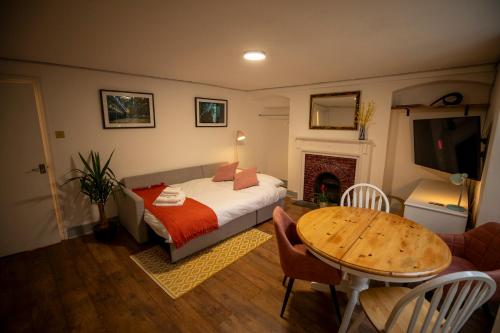 une chambre avec un lit, une table et une cheminée dans l'établissement Base78, Your Place in BristoI, Close to Station, Harbourside & City, à Bristol