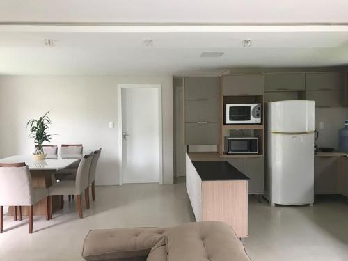 eine Küche und ein Wohnzimmer mit einem Tisch und einem Kühlschrank in der Unterkunft Casa Completa com 2 Quartos no Centro in Pomerode