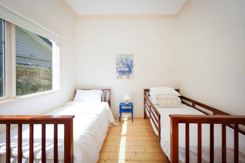 a bedroom with two beds and a window at Twilight Villa - 3 bedroom house in Box Hill in Box Hill