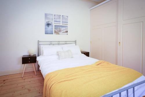 a bedroom with a large bed with a yellow blanket at Twilight Villa - 3 bedroom house in Box Hill in Box Hill