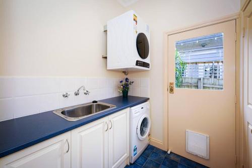 a kitchen with a sink and a washing machine at Twilight Villa - 3 bedroom house in Box Hill in Box Hill
