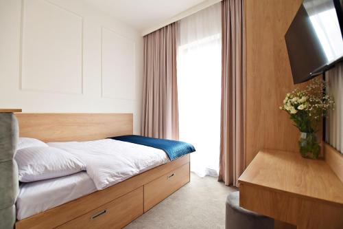a hotel room with a bed and a television at IVY Healthy Stay in Konstancin-Jeziorna