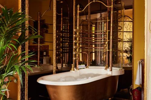 a bath tub in a bathroom with a plant at The Portobello Hotel in London