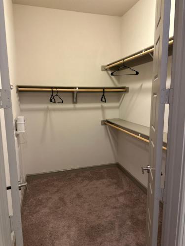 an empty walk in closet with two shelves at Downtown Houston Cozy Queen Suite in Houston