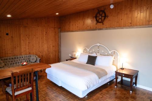 a bedroom with a white bed and a wooden wall at Albert's in Shelburne