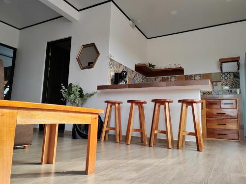 uma cozinha com uma mesa de madeira e quatro bancos em Villas Brisas de Soley em La Cruz