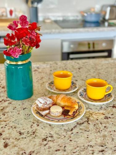 two plates of food on a counter with two cups at Departamento Elegante en Torre Leloir in Villa Marini