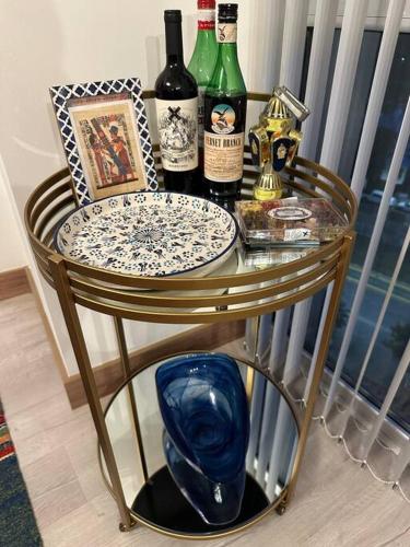 a glass table with bottles of wine on top of it at Departamento Elegante en Torre Leloir in Villa Marini