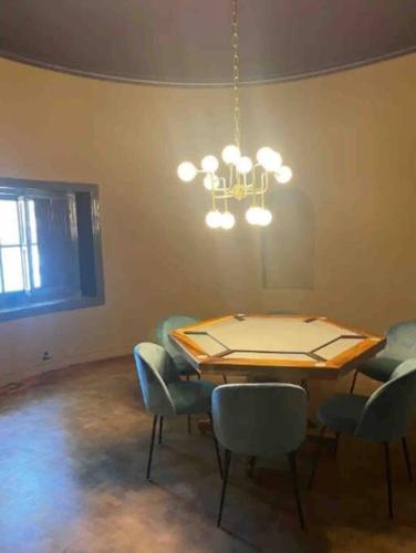 a dining room with a table and chairs and a chandelier at Departamento Elegante en Torre Leloir in Villa Marini