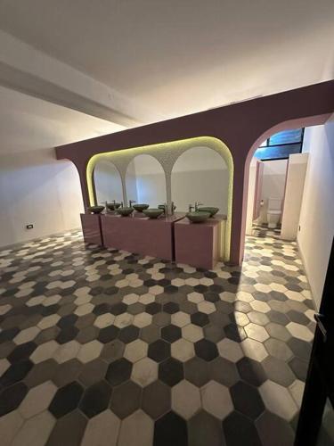 a bathroom with three sinks and a checkered floor at Departamento Elegante en Torre Leloir in Villa Marini