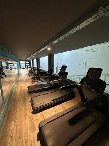 a row of treadmills in a gym with a wooden floor at Departamento Elegante en Torre Leloir in Villa Marini