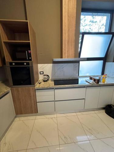 a kitchen with a counter with a microwave and a window at Departamento Elegante en Torre Leloir in Villa Marini