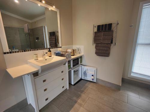 bagno con lavandino bianco e specchio di Hidden Valley Private Guest Suite with Views a South Grafton