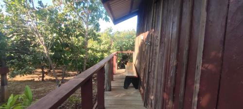 a wooden walkway to a building with a bench on it at Tree Trails Homestay & Offers Jungle Trekk-Scooter For Rental in Banlung