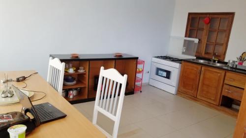 a kitchen with a table with a laptop on it at House Cidadela in Praia