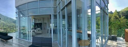 una casa in vetro con vista su un soggiorno di 360* Ultimate Penthouse Entire TOP FLOOR and RESORT with GREAT AMENITIES a Kamala Beach