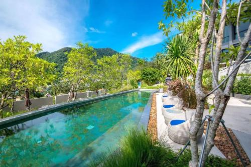 una piscina con alberi e montagne sullo sfondo di 360* Ultimate Penthouse Entire TOP FLOOR and RESORT with GREAT AMENITIES a Kamala Beach