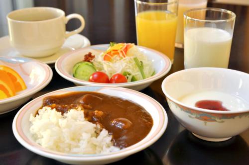 a table topped with plates of food and bowls of rice at Hotel Lifort Sapporo in Sapporo