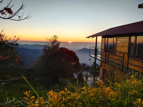 a house with the sunset in the background at MISBHA HomeStay in Kodaikānāl