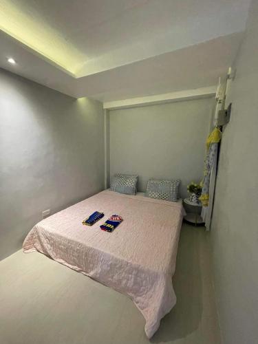 een kleine slaapkamer met een bed met een roze deken bij Eri transient house Tagum in Tagum