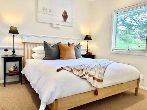 een slaapkamer met een groot wit bed met kussens bij Autumn Beauty - Alpine Cottage 5 in Bright