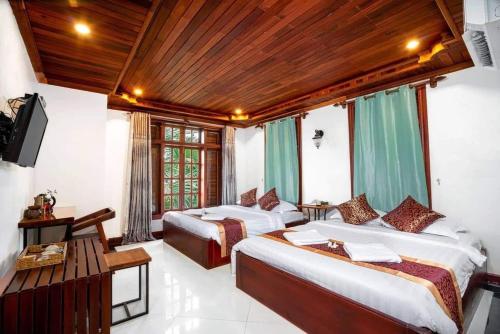 a hotel room with two beds and a television at P5 Angkor Residence in Siem Reap