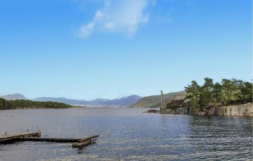 a view of a lake with a dock in the water at Gorgeous Home In Jrpeland With Kitchen in Jørpeland