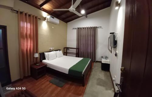 a bedroom with a bed and a tv in it at Forest edge villa in Anuradhapura