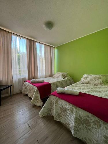 Cette chambre verte comprend 2 lits et une fenêtre. dans l'établissement Departamento equipado 131 Ovalle, à Ovalle