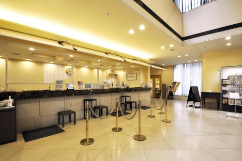 a salon with a counter with stools and a mirror at Hotel Lifort Sapporo in Sapporo
