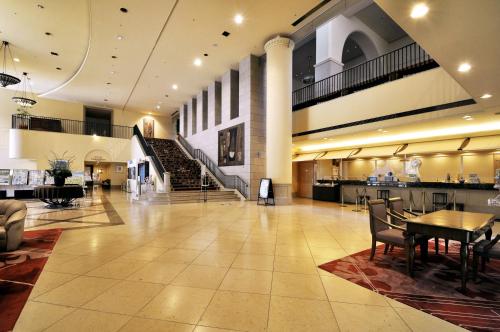 a large lobby with a table and a staircase at Hotel Lifort Sapporo in Sapporo