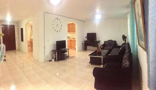 uma sala de estar com um sofá e uma televisão em Seashells Home em Panglao