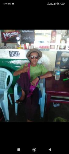 a woman wearing a hat sitting at a counter at Kyaw Swar Hein 