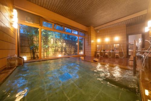 a swimming pool in a room with a large window at Suihoen in Gero
