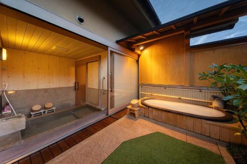 a large bathroom with a tub and a plant at Suihoen in Gero