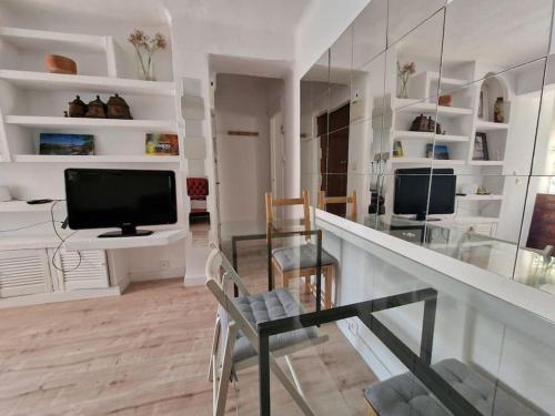 - un salon avec une télévision et un comptoir en verre dans l'établissement Porthos, bonito apartamento zona Puerta del Ángel, à Madrid