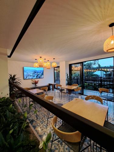 un restaurante con mesas, sillas y ventanas grandes en Guatapé Country House Hotel en Guatapé