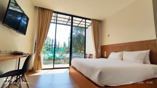 a hotel room with a bed and a large window at The Grand Jamjuree Resort Lamphun in Ban Si Dam