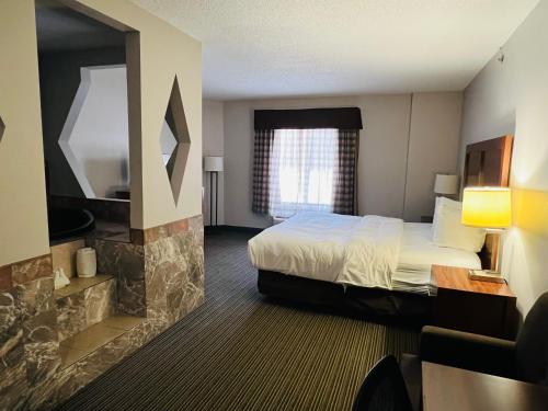 a hotel room with a bed and a fireplace at Country Inn & Suites by Radisson, Battle Creek, MI in Battle Creek