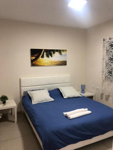 una camera con letto blu e 2 cuscini bianchi di סוויטת מגידו a Midrakh ‘Oz