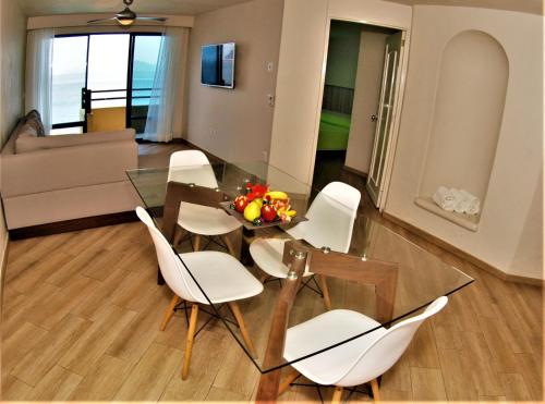 a dining room with a glass table and white chairs at Hotel Marina Puerto Dorado - Todo Incluido in Manzanillo