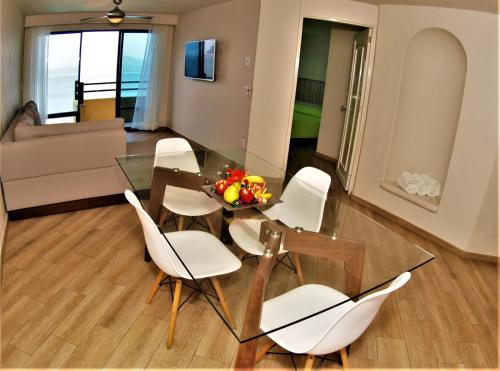 une salle à manger avec une table en verre et des chaises blanches dans l'établissement Hotel Marina Puerto Dorado - Todo Incluido, à Manzanillo