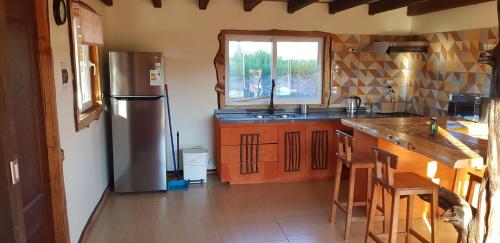 eine Küche mit einem Kühlschrank aus Edelstahl und Holzschränken in der Unterkunft Rancho Eben Ezer in Puyehue