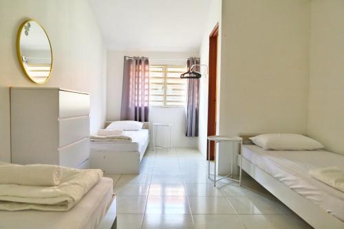 1 dormitorio con 2 camas y espejo en Adno Homestay#4BR#12 Single 2 Sb#High Speed Wifi#14pax, en Simpang Ampat