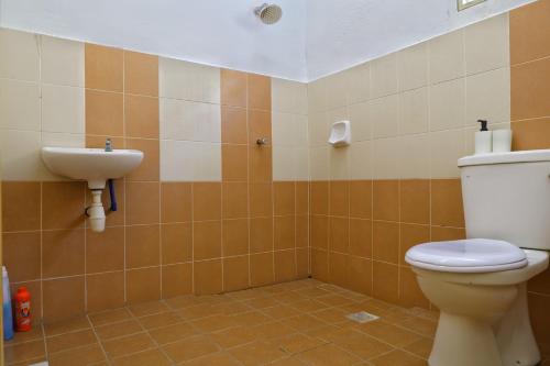 y baño con aseo y lavamanos. en Adno Homestay#4BR#12 Single 2 Sb#High Speed Wifi#14pax, en Simpang Ampat