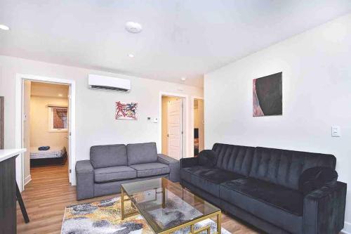 a living room with a black couch and a table at Beautiful 4-BDR in Heart of Plateau Mont-Royal in Montréal
