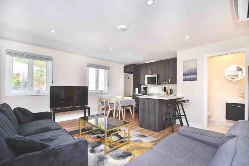 a living room with a couch and a table and a kitchen at Beautiful 4-BDR in Heart of Plateau Mont-Royal in Montréal