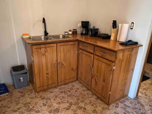 a kitchen with wooden cabinets and a sink at Cabaña junto al río in Naranjito