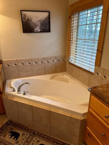 a large white bath tub in a bathroom at The Dream Road Escape Cabin and Hot Tub in Hendersonville